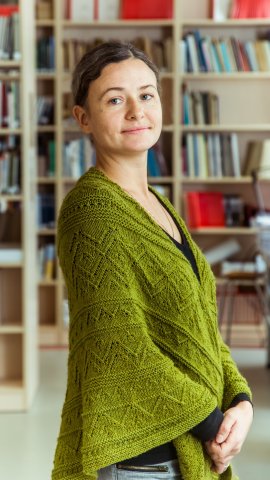 Rohelise kampsuniga naine seisab 