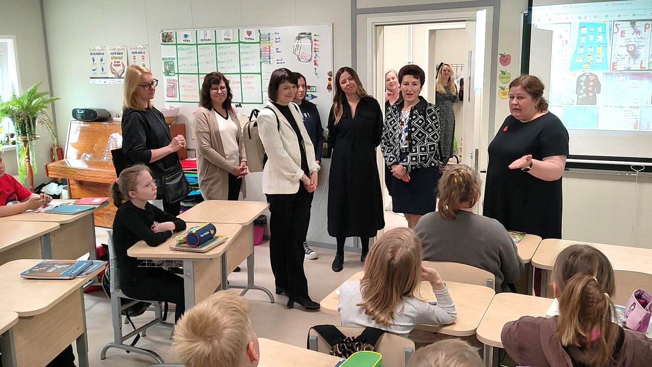 Lõpuseminaril osalejad Mustamäe Gümnaasiumi moodulmajaga tutvumas ja vestlemas õpetaja Tiina Tamiga.