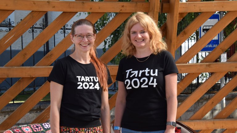Kaks naist seisavad kõrvuti. Särkide peal on kirjas Tartu 2024